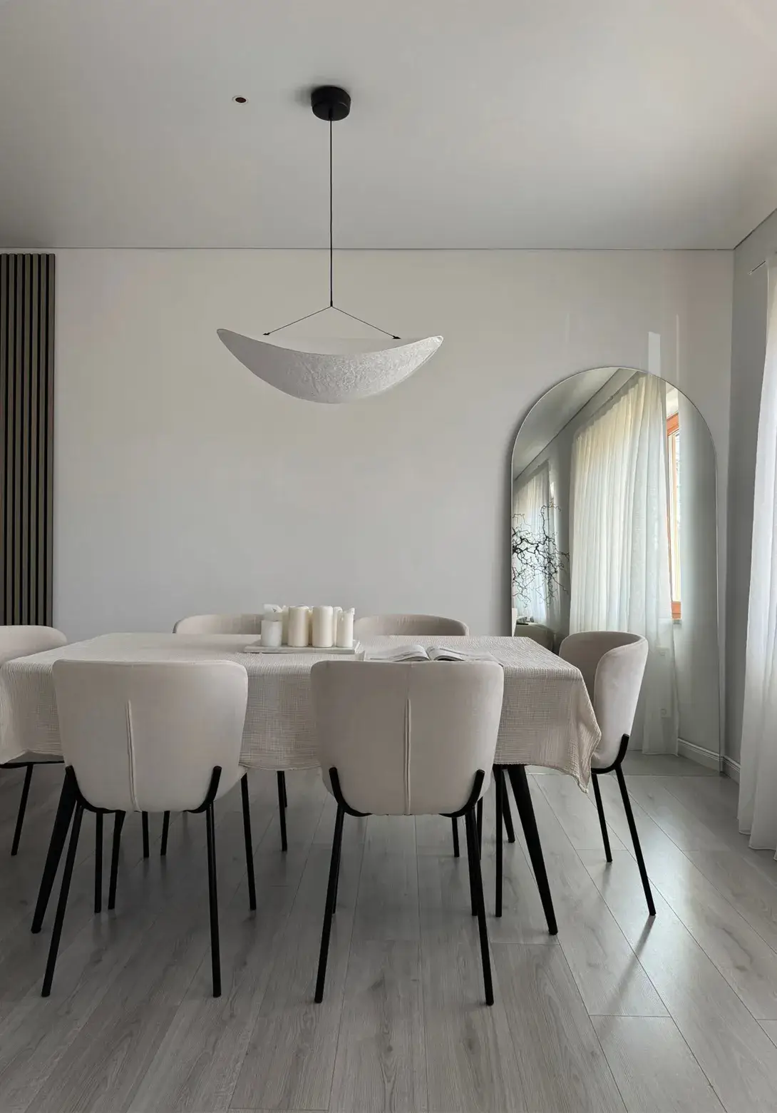 Moderner Essbereich mit hellem Tisch, gepolsterten Stühlen und großem Wandspiegel